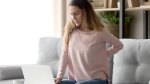 Girl-Working-On-Computer-Sitting-On-Couch-With-Aching-Back