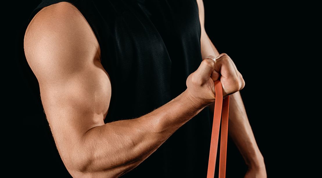 Мужчина выполняет упражнение на бицепс с лентой