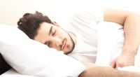 Man sleeping deeply and comfortably on his sides of the bed