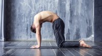 Man demonstrating Yoga position cat cow pose and exercise with just his bodyweight