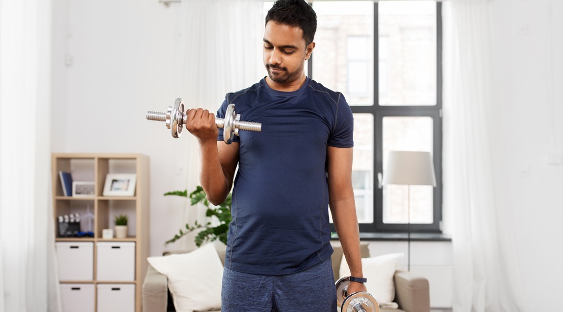 Indian-Man-Performing-Bicep-Curls-Exercise-at-Home-Living-Room