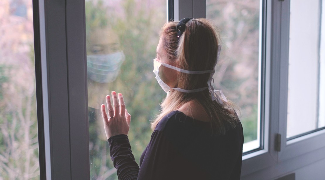 Woman wearing Coronvirus-Face-Mask Looking Out The Window