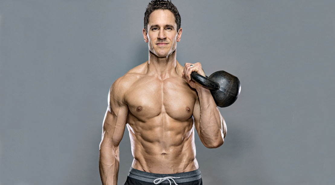 Don Saladino holding a kettlebell with his shirt off.