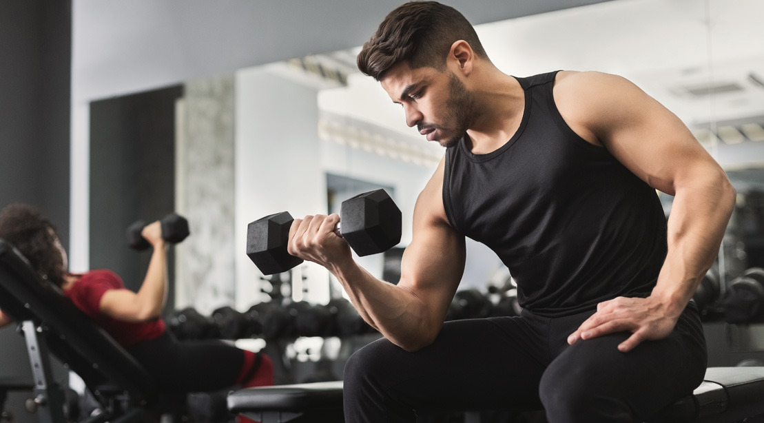 Young man working out biceps with dumbbell curl exercise