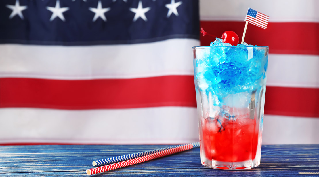 A red white and blue cocktail in front of the American Flag