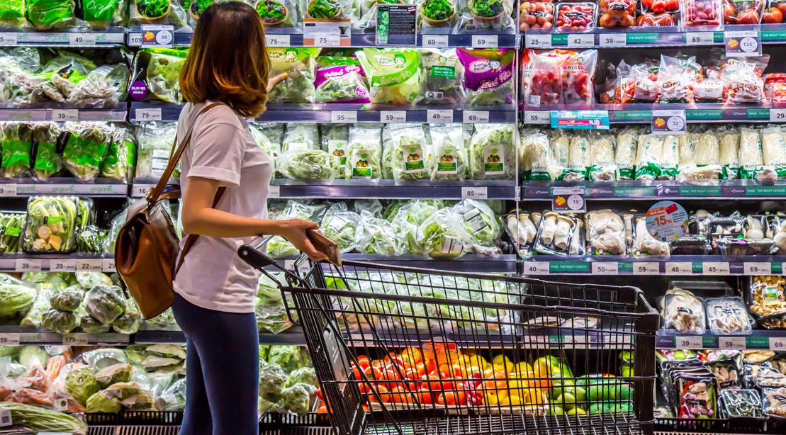 Female in the grocery store looking at packaged produce