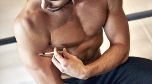 Bodybuilder injecting his biceps with steroids in a needle