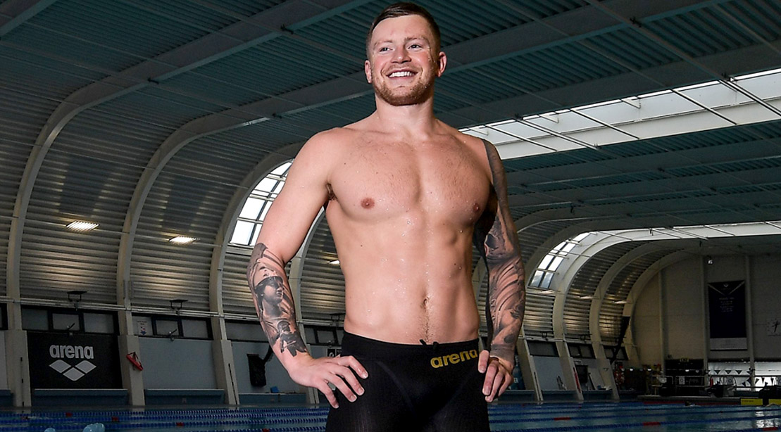 2016 Rio Olympic Gold Medal Swimmer Adam Peaty posing in an indoor pool