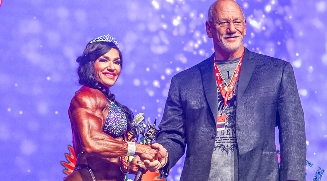 Helle Trevino shaking hands with Wings of Strength CEO Jake Wood at a female bodybuilding competition