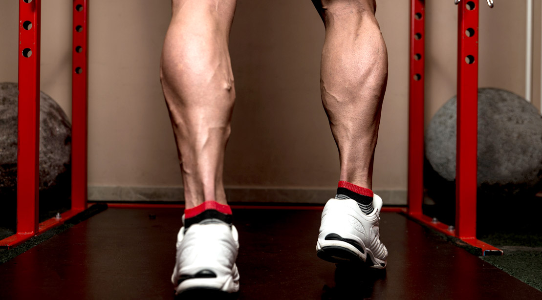 Bodybuilder with muscular calf muscles at the smith machine