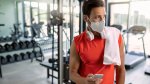 Physically fit gym goer wearing a mask in a gym