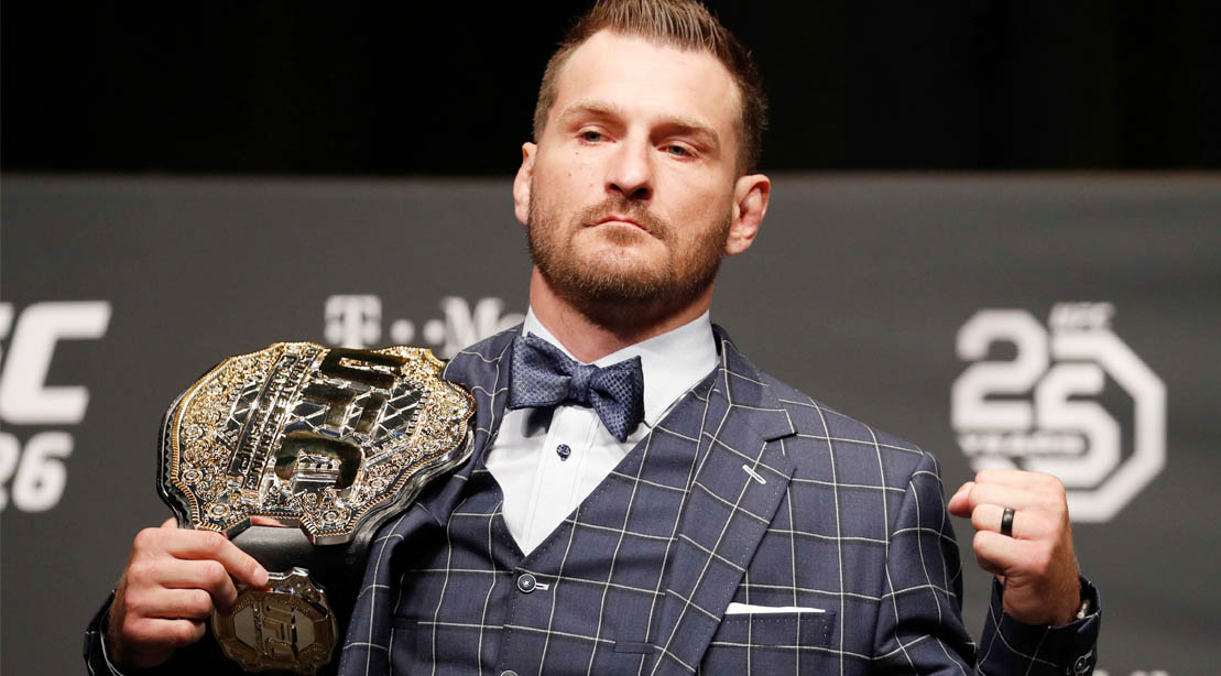 UFC champion fighter and MMA fighter Stipe Miocic posing with the UFC Championship Belt