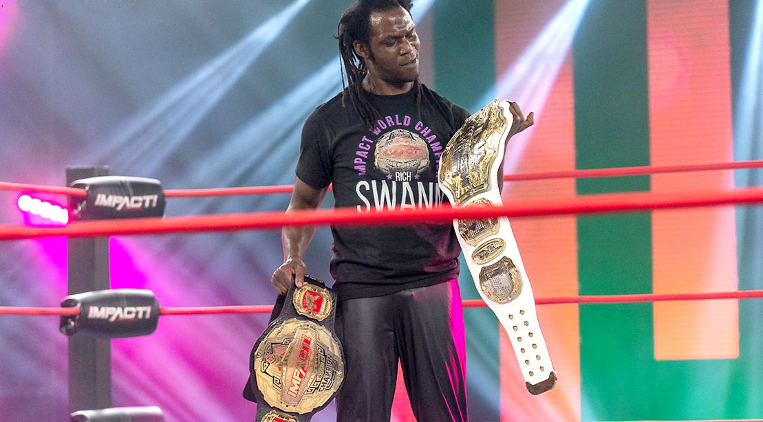 Professional wrestler Rich Swann holding two wrestling championship belts in the wrestling ring