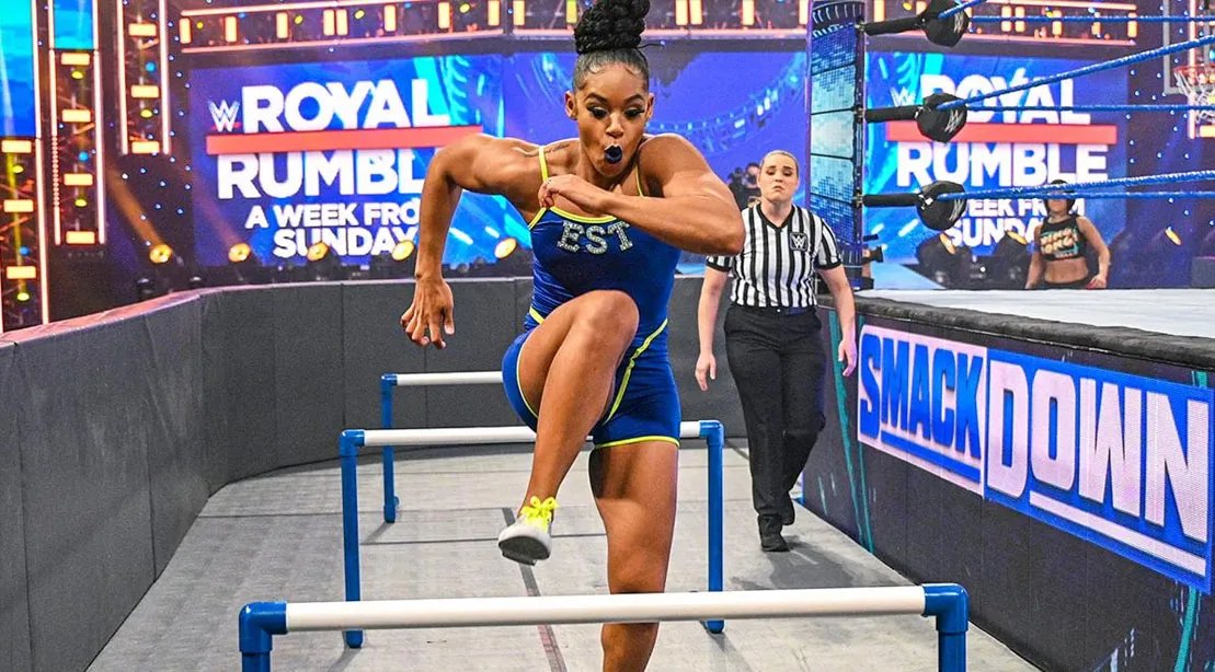 WWE Wrestler Bianca Belair running track hurdles around the wwe wrestling ring