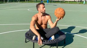 Davide Panzeri Holding A Basketball while sitting on a black trampoline