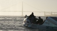 Endurance Athlete Jason Caldwell and his rowing team competing in the Great Pacific Race rowing in front of the Golden Gate Bridge