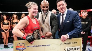 Professional MMA fighter of the Professional Fighter League Kayla Harrison recieving a check from Mike Tyson and the PFL president