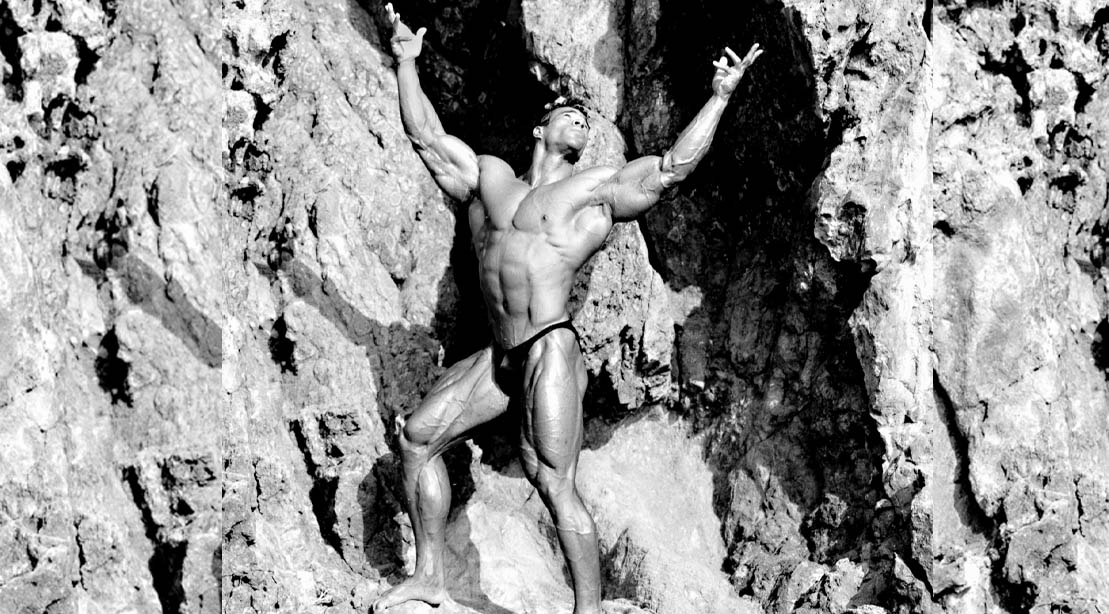 Bodybuilder Kevin Levrone posing against a mountain side
