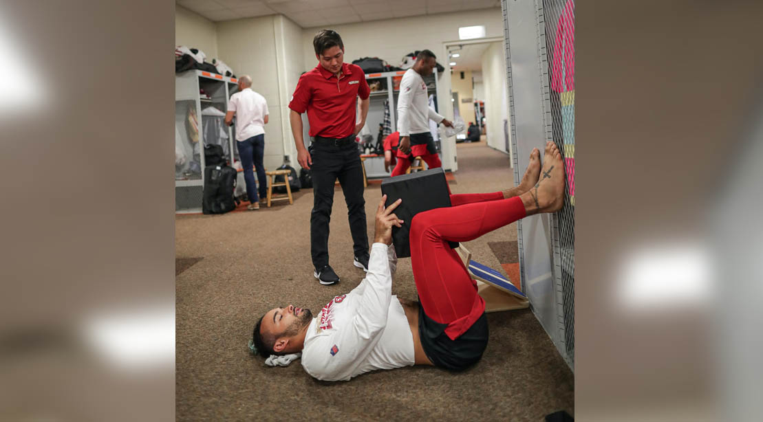NFL 49er trainer Tom Zheng training a 49ers football player in the locker room