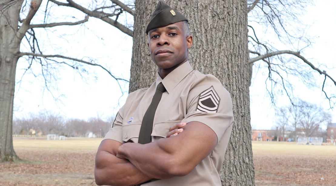 Army National Guard and bodybuilder Ricardo Hamer in his army uniform leaning against a tree
