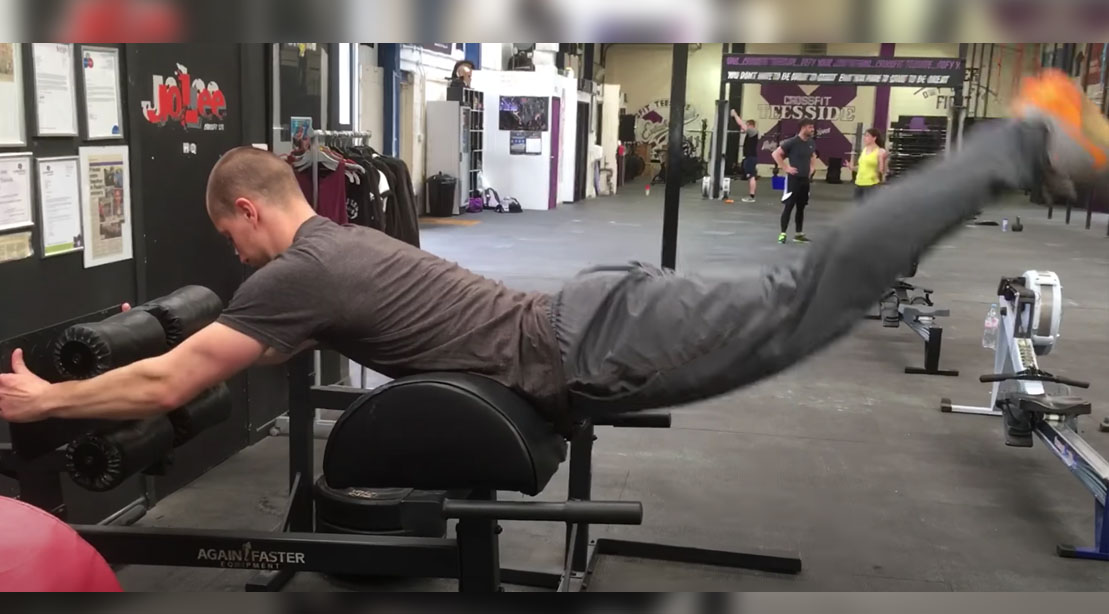 Man performing a reverse hyperextension exercise in the gym