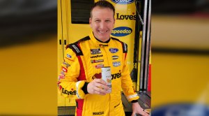 Nascar driver and Daytona 500 Winner Michael McDowell drinking a can of soda wearing his race car uniform