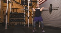 Nascar racer Ricky Stenhouse performing a jerk and clean with a barbell in his home gym