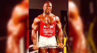 Lee Haney working out in the gym with biceps curls using a preacher bar