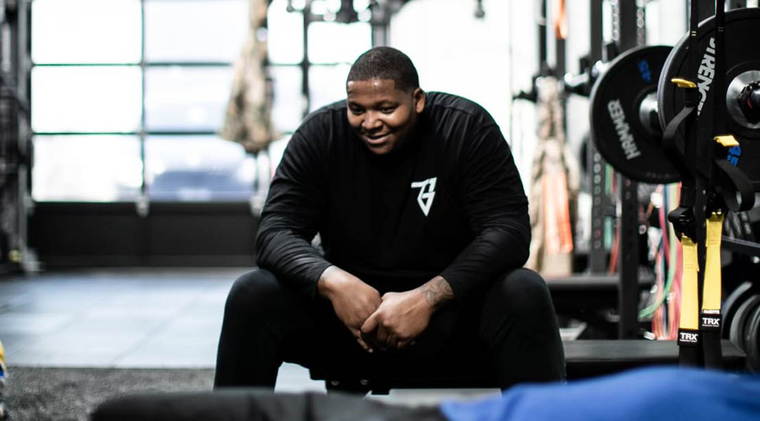 NFL New England Patriots Linebacker Trent Brown sitting on a bench in the gym