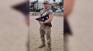 Navy seal veteran John MacLaren holding an folded American flag