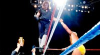 The Undertaker walking on the ring ropes while holding Hulk Hogans hand