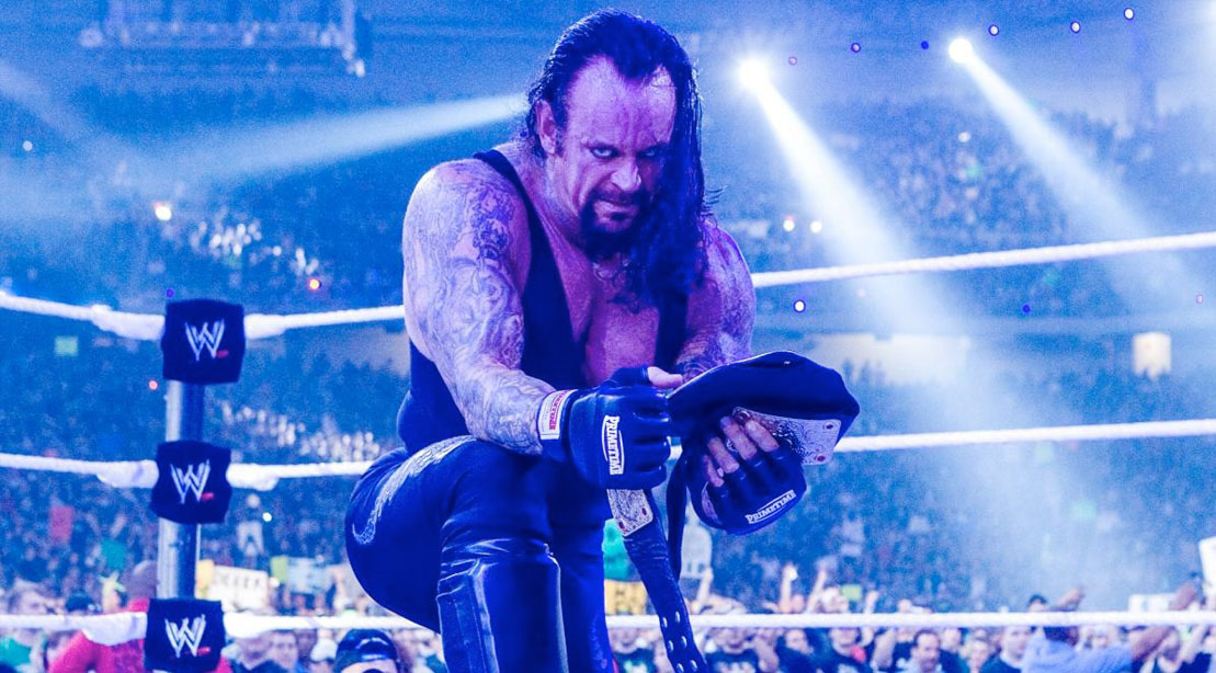 WWE professional wrestler The Undertaker taking a knee in the squared circle