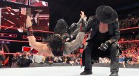 Wrestler The Undertaker chocke slamming Roman Reigns
