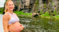 Crossfit champion and mother Annie Thorisdottir showing her baby bump next to a river