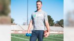 NFL Football Player for the Kansas City Chiefs Alex Smith holding a UCAN and football