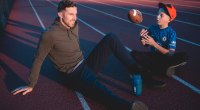 NFL quarterback for the Kansas City Chiefs sits on the track while his son throws up a football