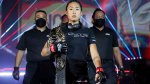 ONE MMA Fighter Angela Lee walking down the ring holding her atomweight championship belt