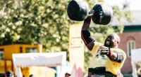 Strongman Mark Felix holding a large dumbbell over his head
