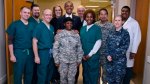 Captain Cherissa Jackson of HEAL program for AMVETS wearing medical scrubs with former President Obama
