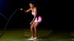 Female wrestler Brandi Rhodes working out with battle ropes exercise