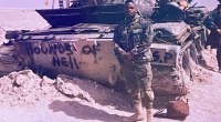 Johnnie Jackson in full military gear in front of a Hounds of Hell tank