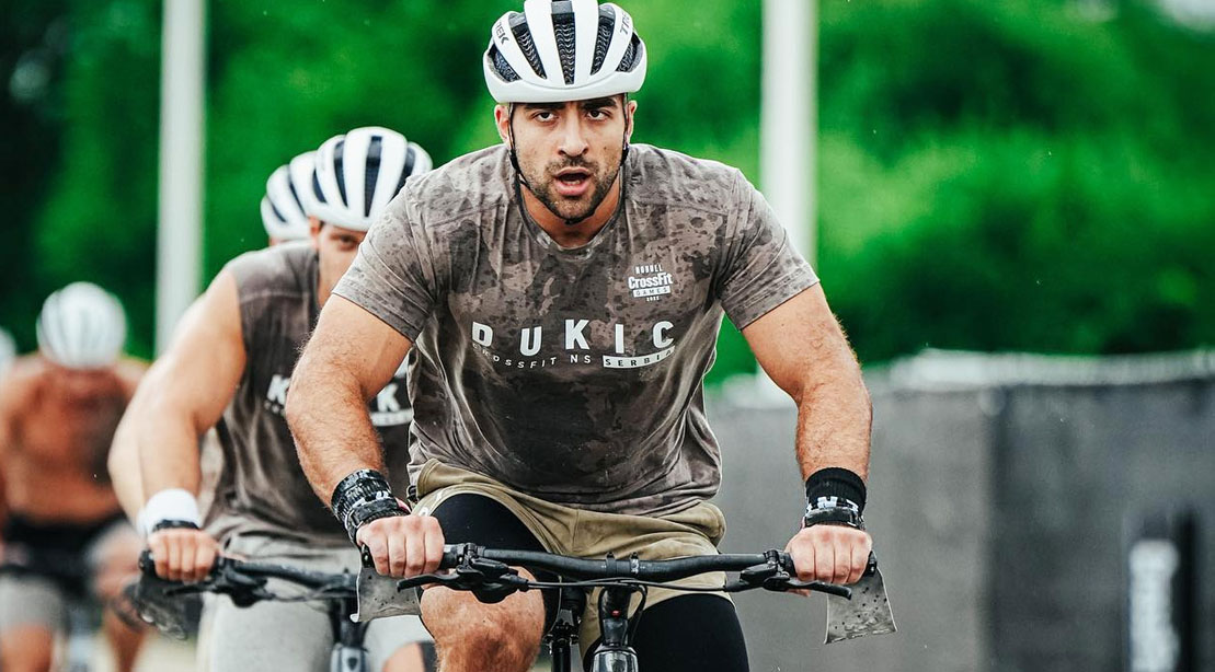 Crossfitter Dukic at the crossfit games 2022 riding a bike