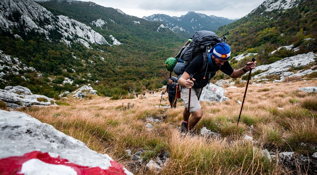 Highlander adventure participant hiking through a mountain region