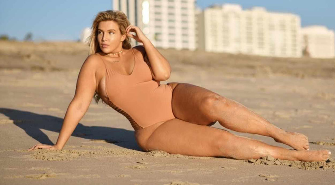 Playboy cover model and plus size role model Stephanie Viada on the beach wearing a one piece bathing suit