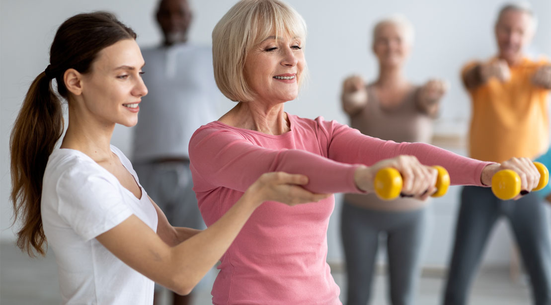 Elderly female working out with dumbbells during menopause