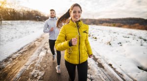Fit young couple cold weather training in the winter wearing cold weather items