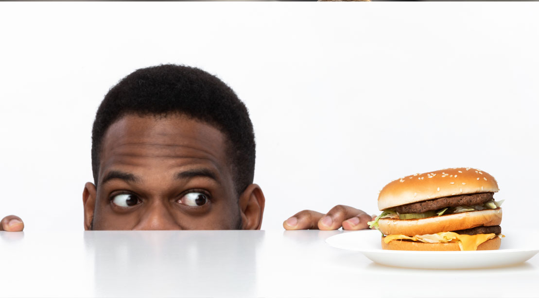 Man eyeing a and craving a fastfood burger and displaying the Gut-Brain Connection