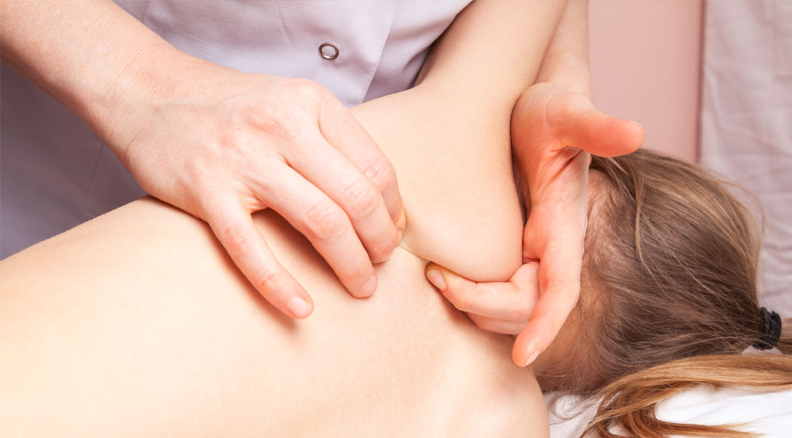 Masseuse massaging and treating a winged scapula