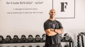 Personal trainer Sal Alosi in front of his gym's logo