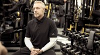 Celebrity trainer Gunnar Peterson sitting on a bench in the gym giving training and workout tips